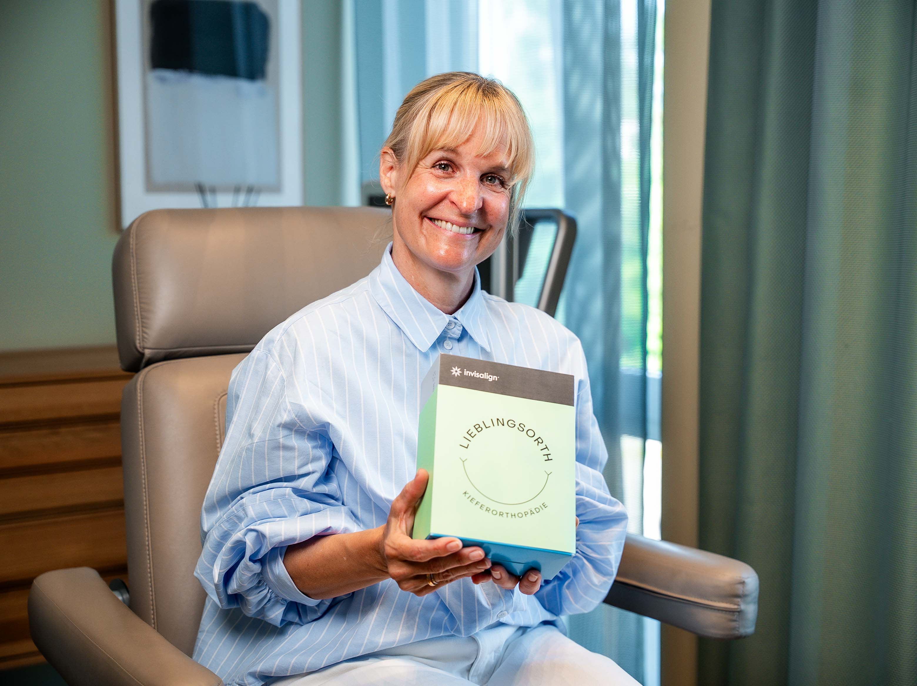 Patientin mit ihrer Invisalign Schienen-Box von Lieblingsorth